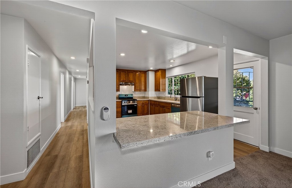 201 Primrose Avenue Redlands, CA 92373 - Photo 9 of 23 a large kitchen with stainless steel appliances kitchen island a large counter top and a refrigerator