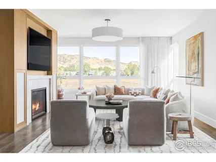 a living room with furniture a fireplace and a floor to ceiling window
