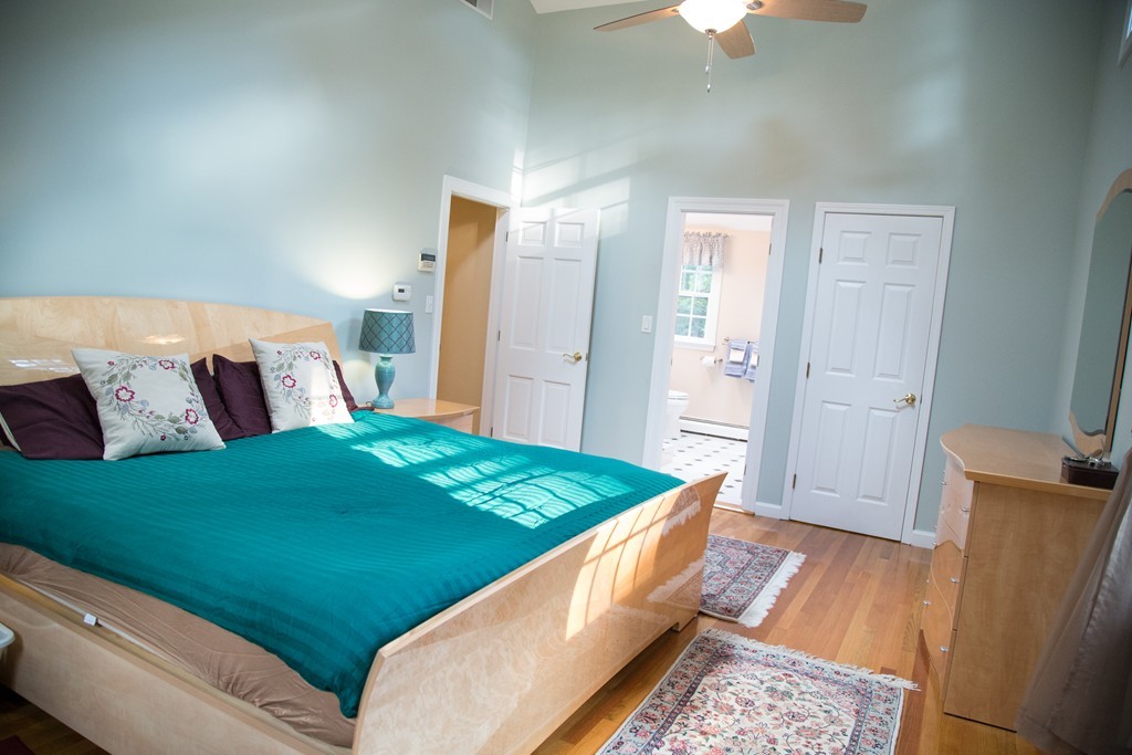 3 Carriage Way Topsfield, MA 01983 - Photo 20 of 30 a bed room with a bed and a chandelier