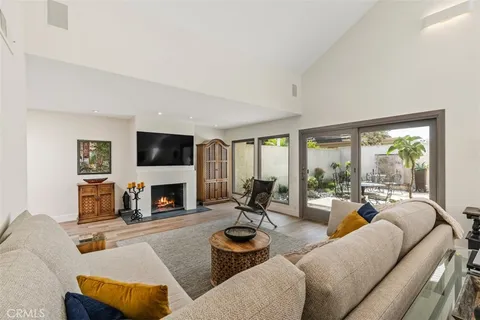 a living room with furniture fireplace and a large window