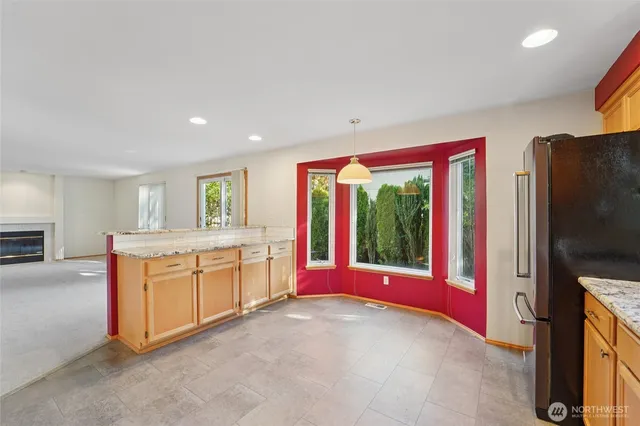 a view of kitchen with stainless steel appliances granite countertop a stove and a large window