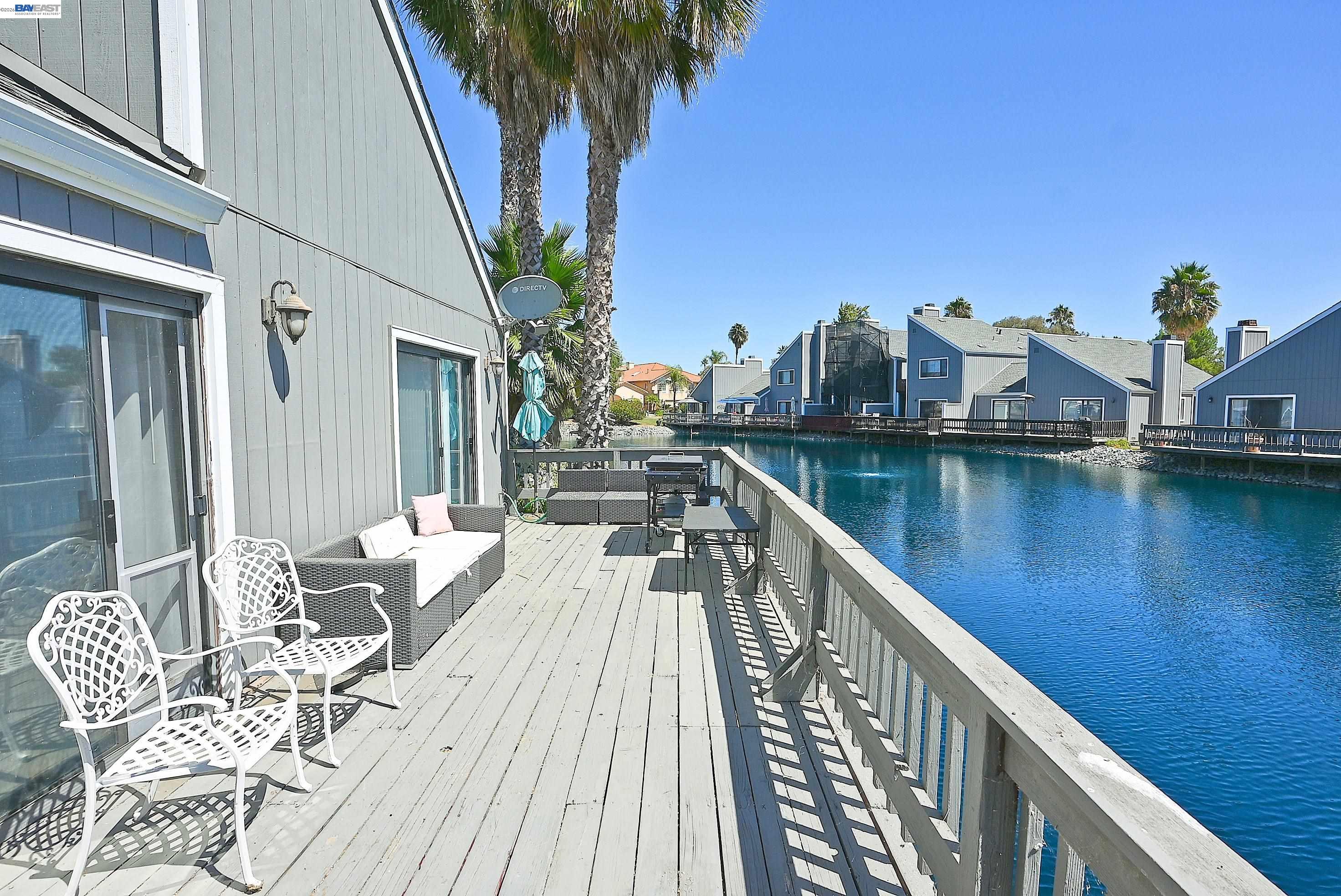 2073 Sand Point Road Discovery Bay, CA 94505 - Photo 13 of 40 a view of a lake with couches chairs and wooden floor