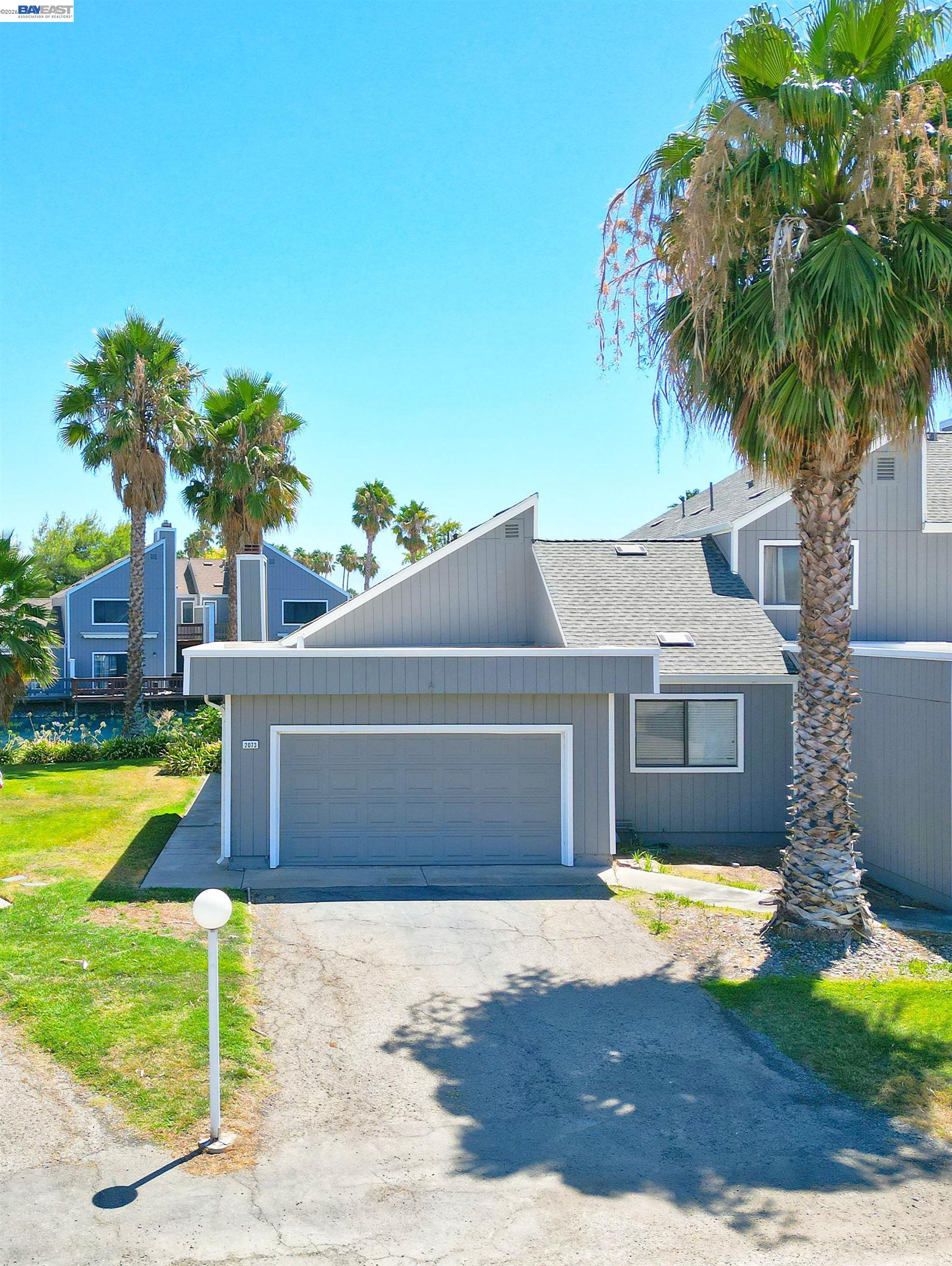 2073 Sand Point Road Discovery Bay, CA 94505 - Photo 2 of 40 a front view of a house with a yard and garage