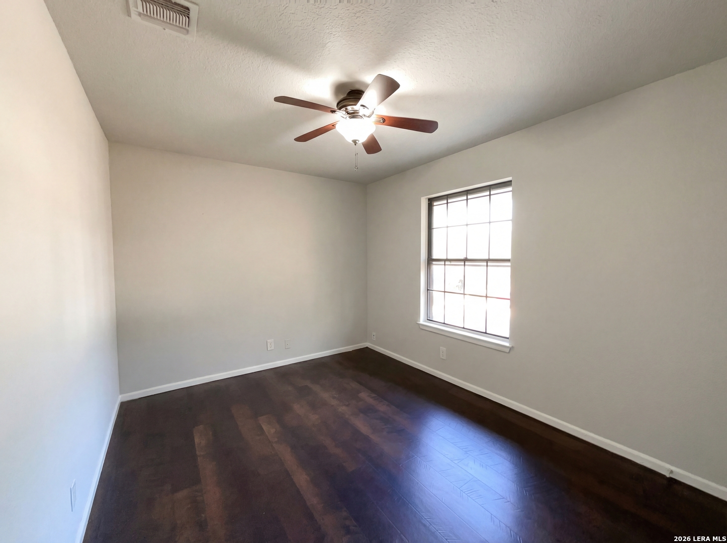 5423 Timberhurst San Antonio, TX 78250 - Photo 16 of 18 an empty room with wooden floor chandelier fan and windows