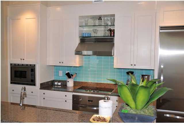 Compass Point, Unit 407 Watersound, FL 32461 - Photo 3 of 7 a kitchen with stainless steel appliances kitchen island granite countertop a sink a stove and a microwave