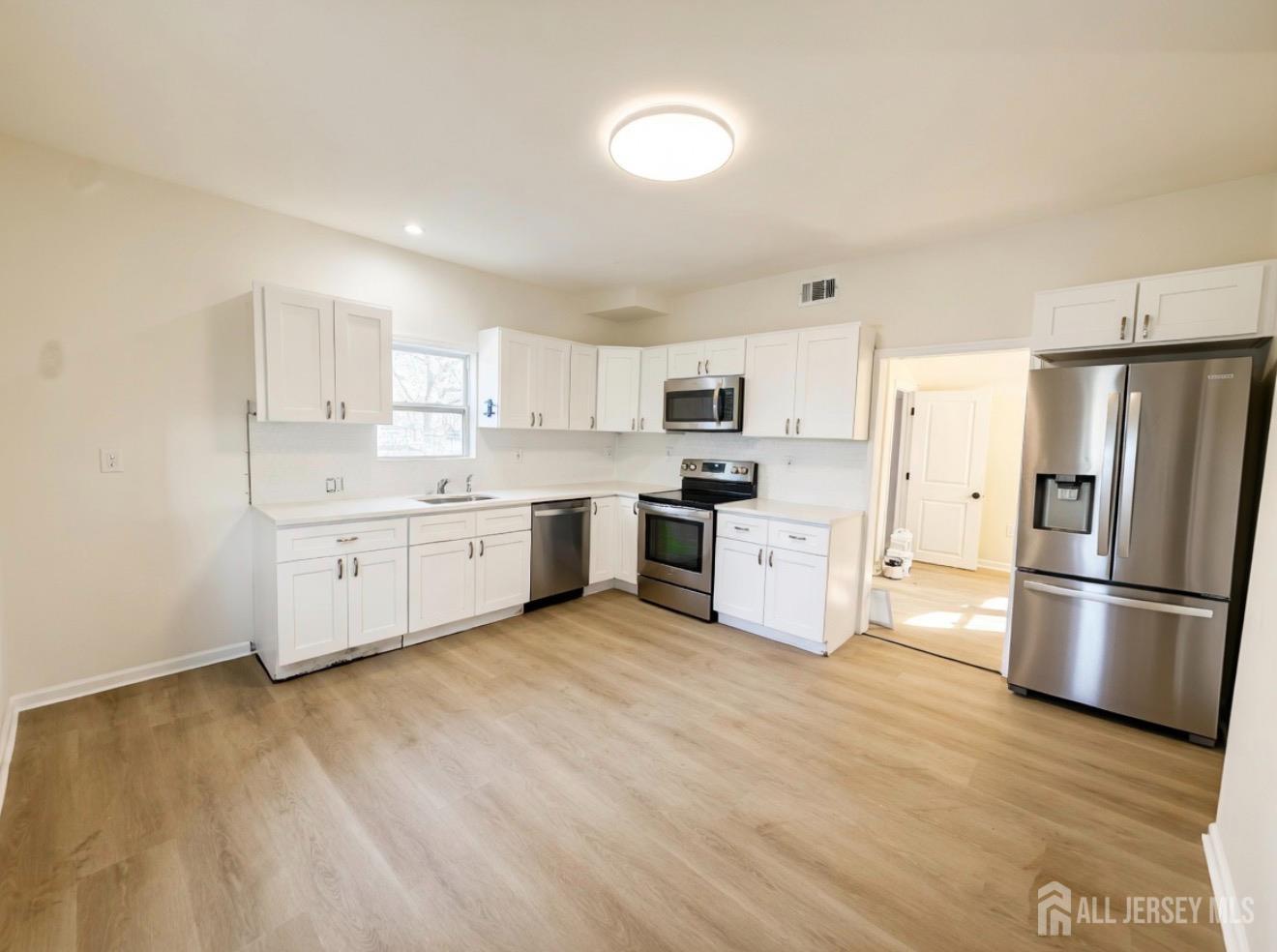 103 Logan Lane Bridgeport, NJ 08014 - Photo 5 of 11 a kitchen with stainless steel appliances a refrigerator sink and microwave