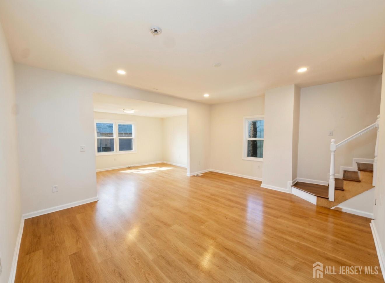 103 Logan Lane Bridgeport, NJ 08014 - Photo 6 of 11 a view of an empty room with wooden floor and a window