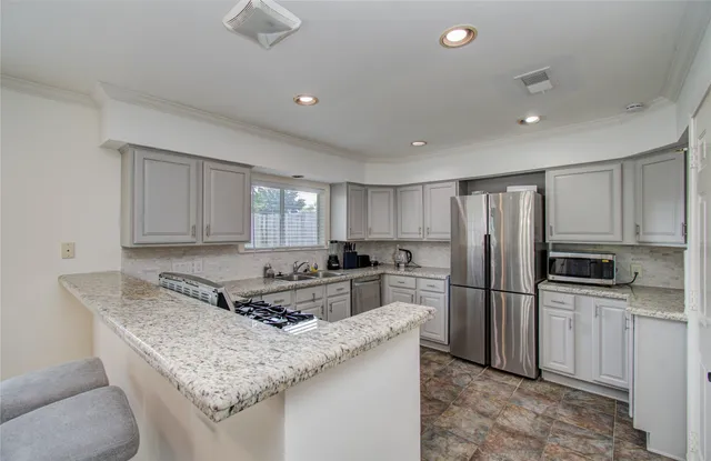 a kitchen with stainless steel appliances granite countertop a sink stove and refrigerator