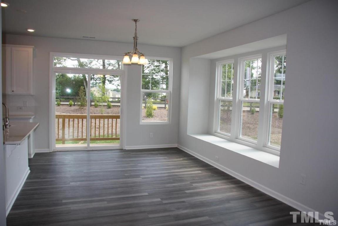 2919 Sunflower Road Apex, NC 27502 - Photo 16 of 34 a view of an empty room with wooden floor and a window