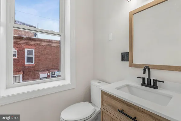 a bathroom with a toilet sink and mirror