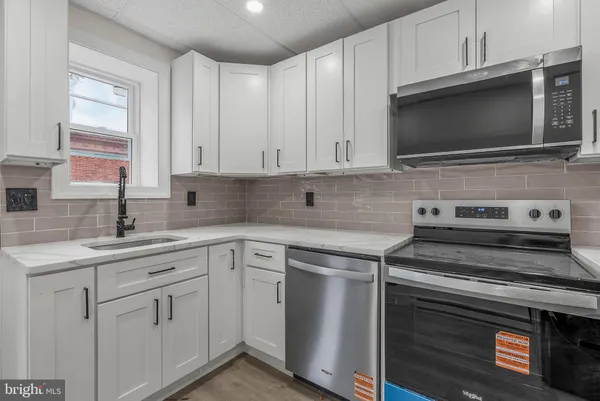 a kitchen with appliances a sink and cabinets