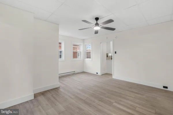 an empty room with wooden floor a ceiling fan and closet
