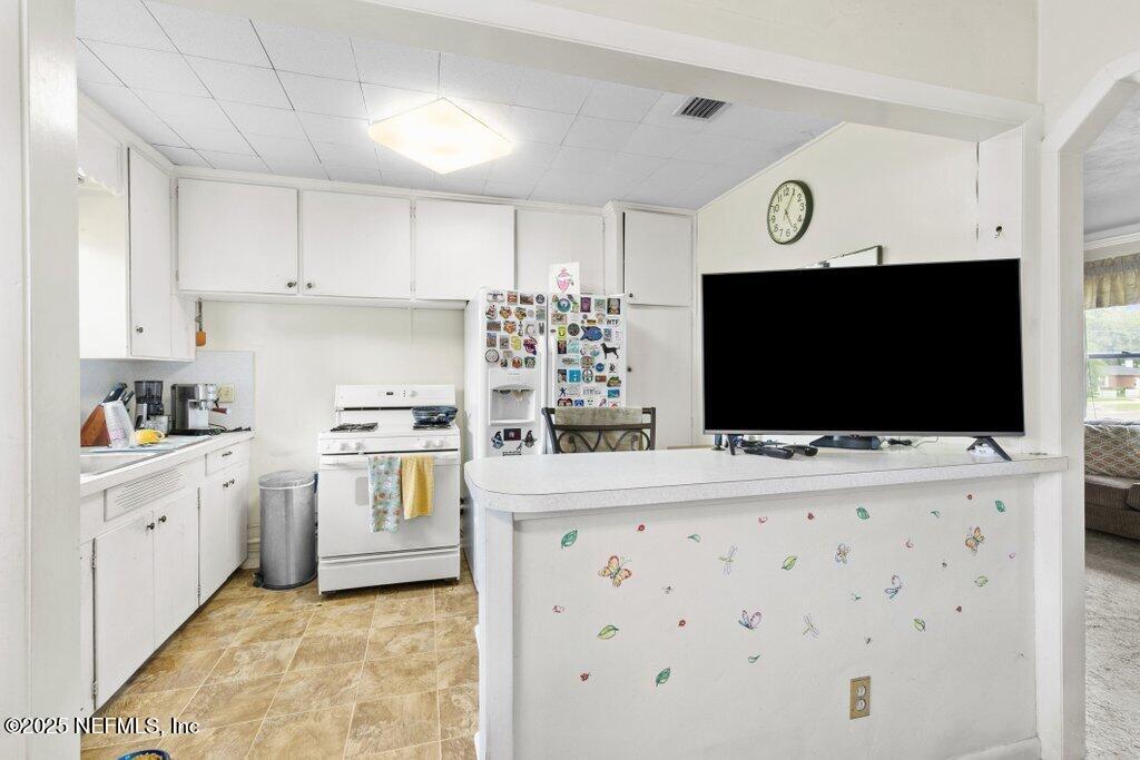 2305 Broward Road Jacksonville, FL 32218 - Photo 14 of 30 a kitchen with stainless steel appliances a stove top oven a sink a microwave and cabinets