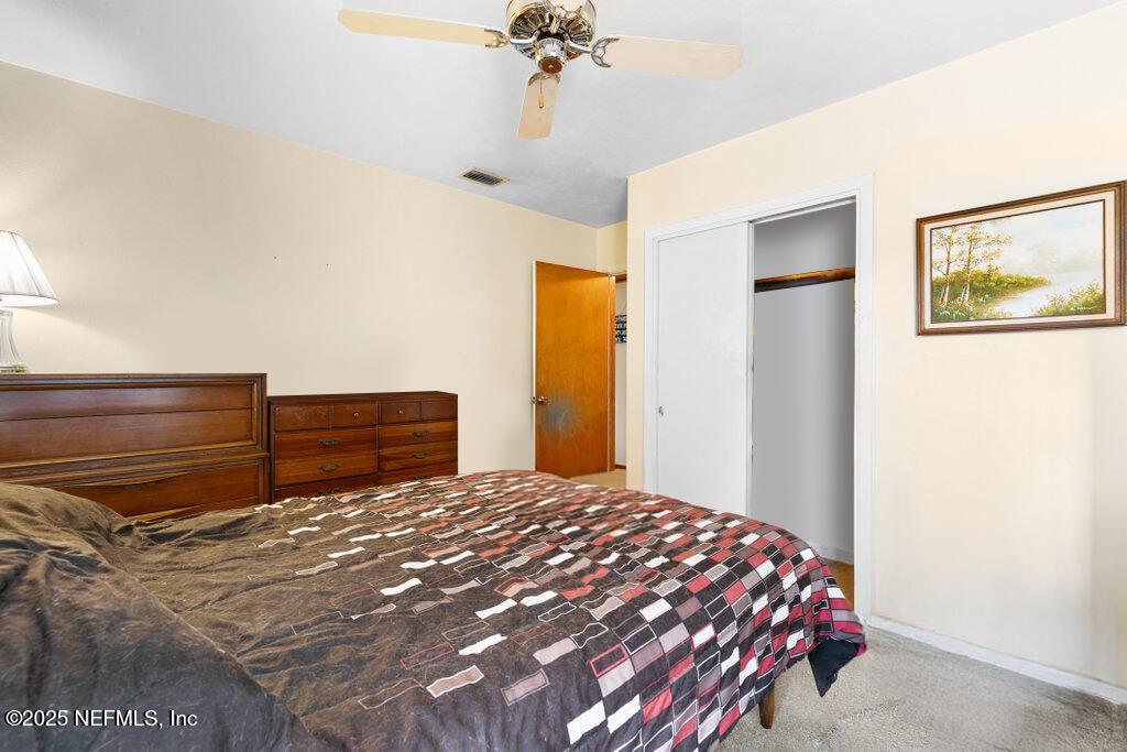 2305 Broward Road Jacksonville, FL 32218 - Photo 18 of 30 a bedroom with a bed and a chandelier