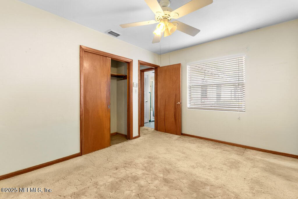 2305 Broward Road Jacksonville, FL 32218 - Photo 23 of 30 an empty room with chandelier fan and windows