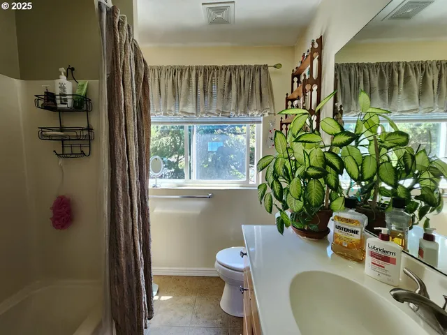 a spacious bedroom with a bed and wooden floor