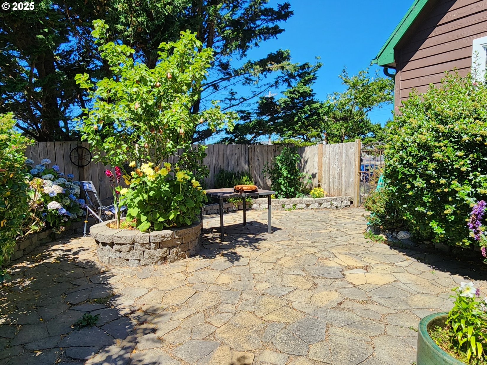 1126 Washington Street Port Orford, OR 97465 - Photo 29 of 32 a bench sitting in middle of flowers in front of a yard