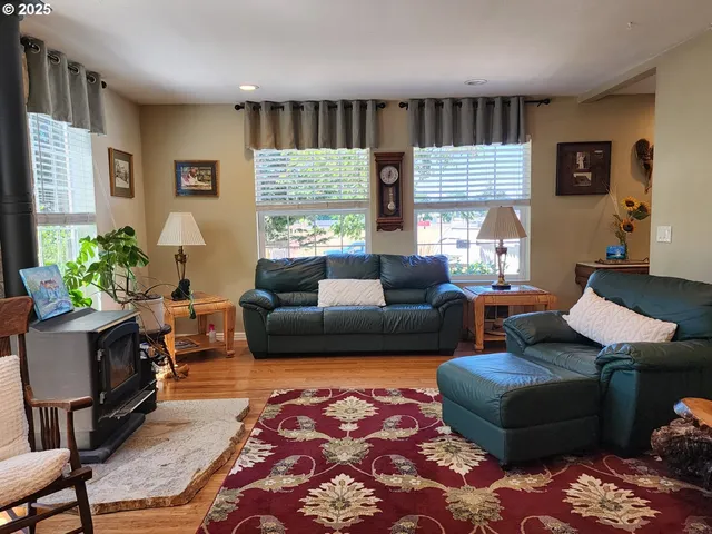 a living room with furniture wooden floor and a large window