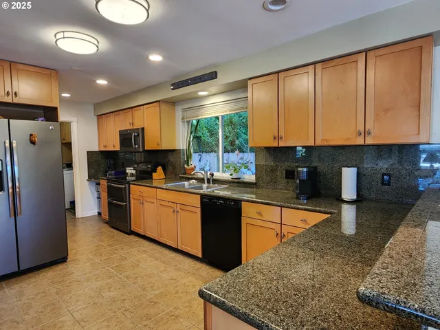 a kitchen with stainless steel appliances granite countertop a refrigerator a sink a stove a microwave and cabinets