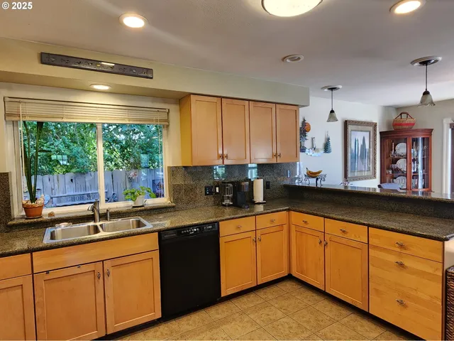 a kitchen with stainless steel appliances granite countertop white cabinets sink and large window