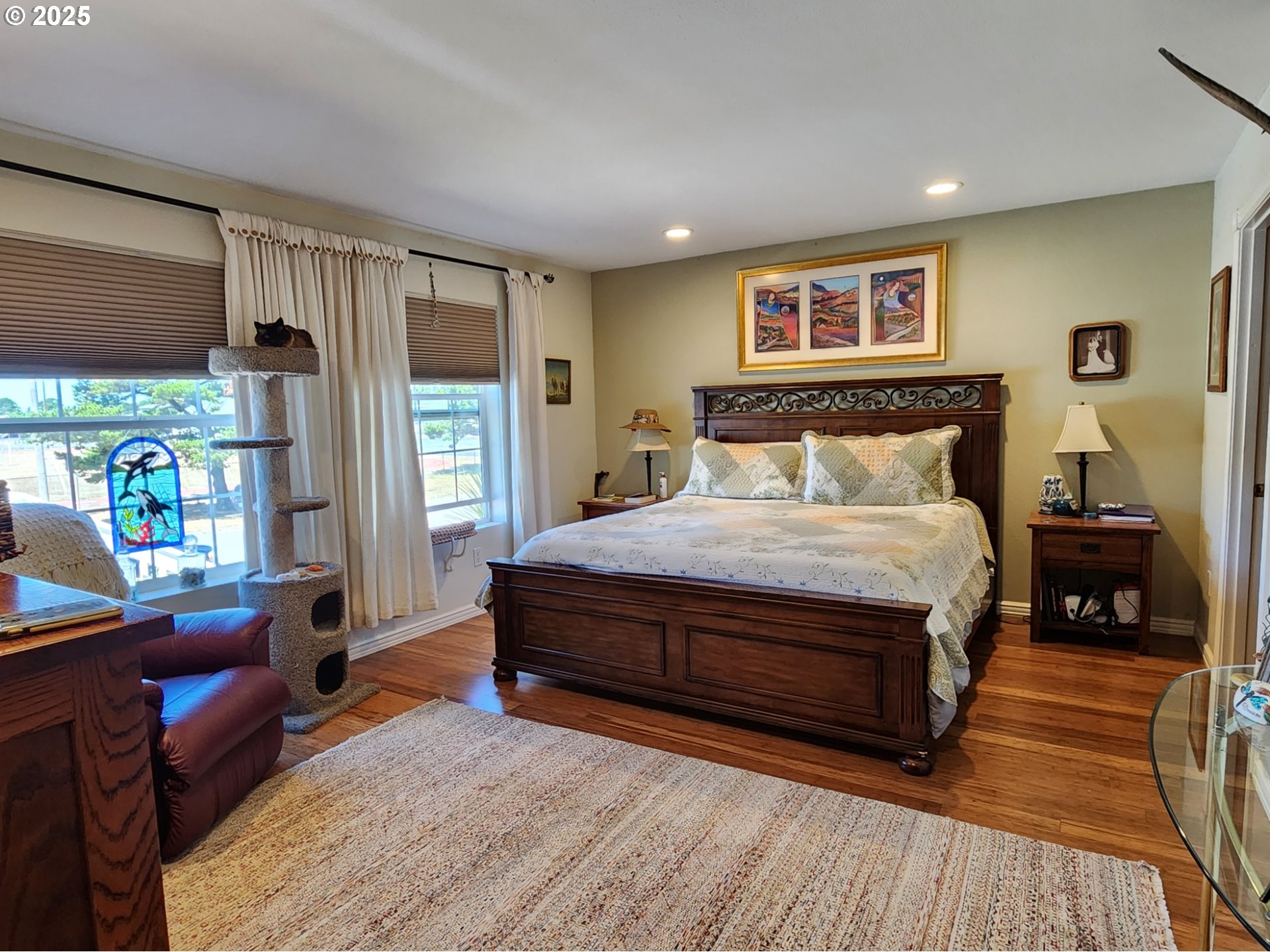 1126 Washington Street Port Orford, OR 97465 - Photo 10 of 32 a bedroom with a large bed a flat tv screen and a dresser