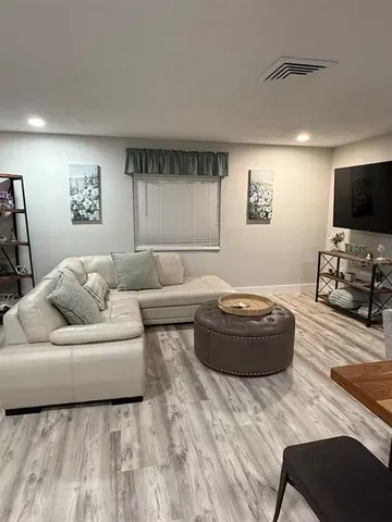 a kitchen with stainless steel appliances kitchen island granite countertop a refrigerator a stove top oven a sink dishwasher a dining table and chairs with wooden floor