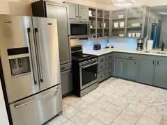 a kitchen with stainless steel appliances granite countertop a refrigerator and a stove top oven