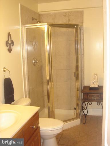 a bathroom with a granite countertop bathtub shower sink vanity and toilet