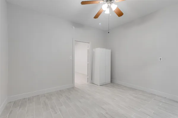 an empty room with a chandelier fan