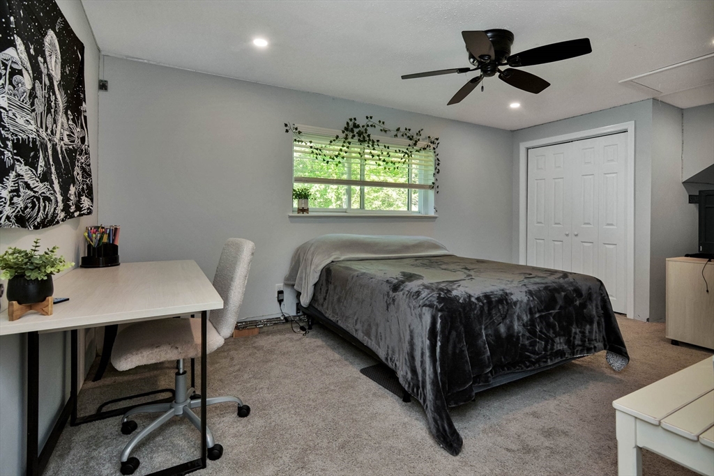 110 Harper Ridge Road Hampstead, NH 03826 - Photo 21 of 32 a spacious bedroom with a bed a desk and chair