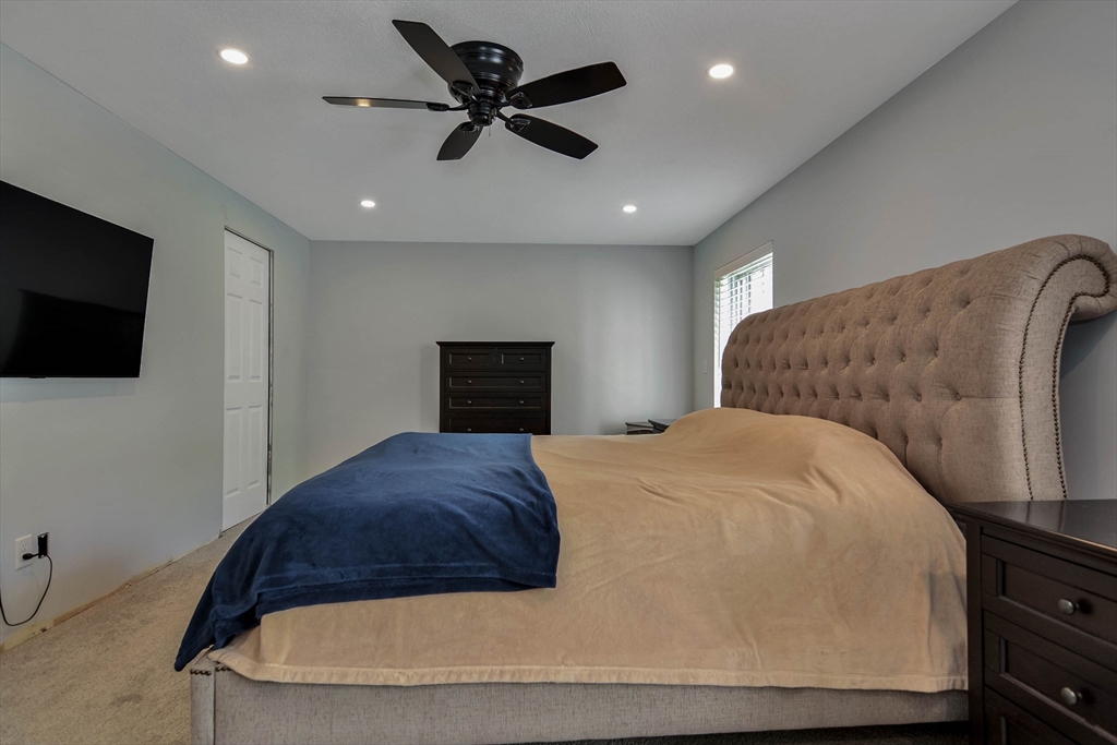 110 Harper Ridge Road Hampstead, NH 03826 - Photo 26 of 32 a bedroom with a bed and a flat screen tv