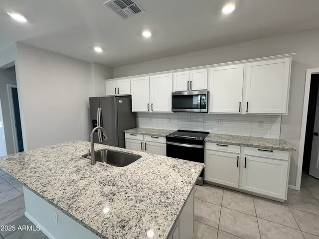 a kitchen with stainless steel appliances granite countertop a sink stove and refrigerator