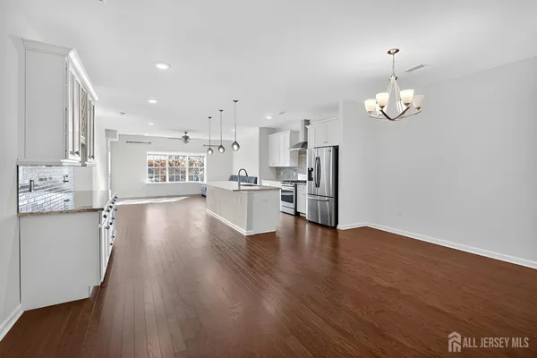 a view of a kitchen with wooden floor and stainless steel appliances