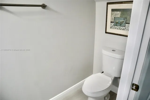 a white toilet sitting next to a white sink and vanity