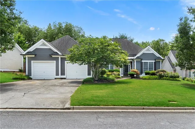 a front view of a house with a yard and trees