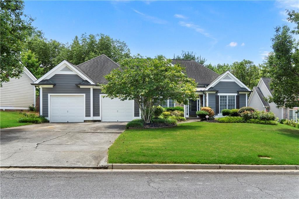 a front view of a house with a yard and trees