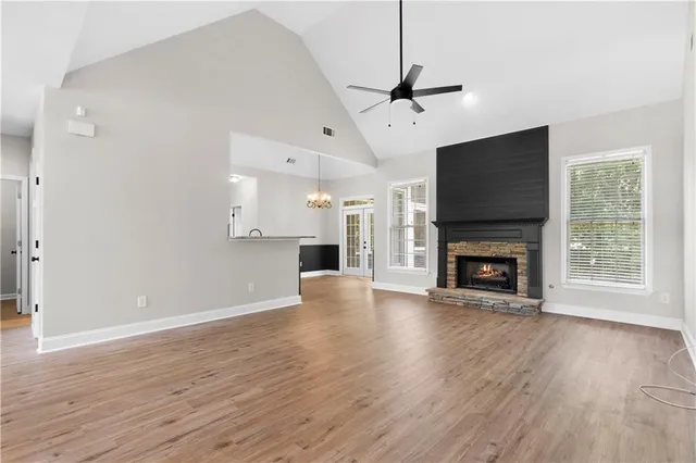 a view of empty room with wooden floor fireplace and a window