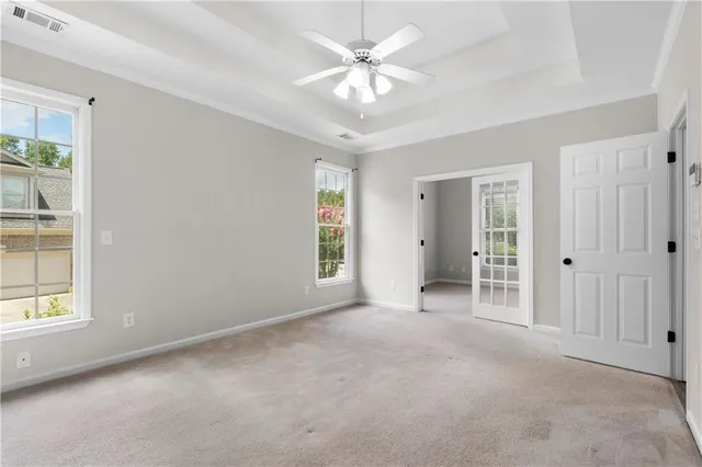 an empty room with windows and ceiling fan