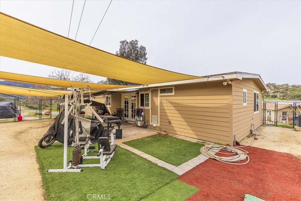 44000 Sandstone Road Aguanga, CA 92536 - Photo 23 of 31 a view of a patio with table and chairs a barbeque with wooden fence