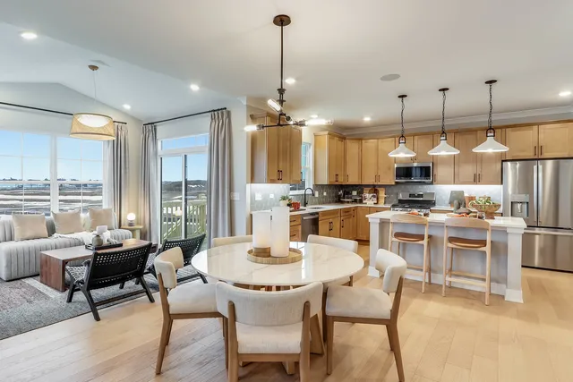 a dining room kitchen island with the kitchen view and a chandelier