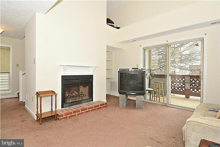 10031 Oakton Terrace Road, Unit 10031 Oakton, VA 22124 - Photo 2 of 19 a living room with furniture a flat screen tv and a fireplace