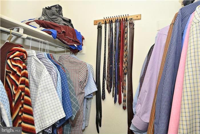 10031 Oakton Terrace Road, Unit 10031 Oakton, VA 22124 - Photo 18 of 19 a view of walk in closet with clothes and shoes