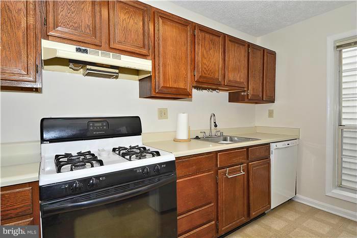 10031 Oakton Terrace Road, Unit 10031 Oakton, VA 22124 - Photo 5 of 19 a kitchen with stainless steel appliances granite countertop a stove a sink and a microwave