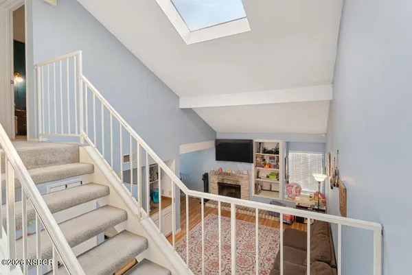 a living room with wooden floor and stairs