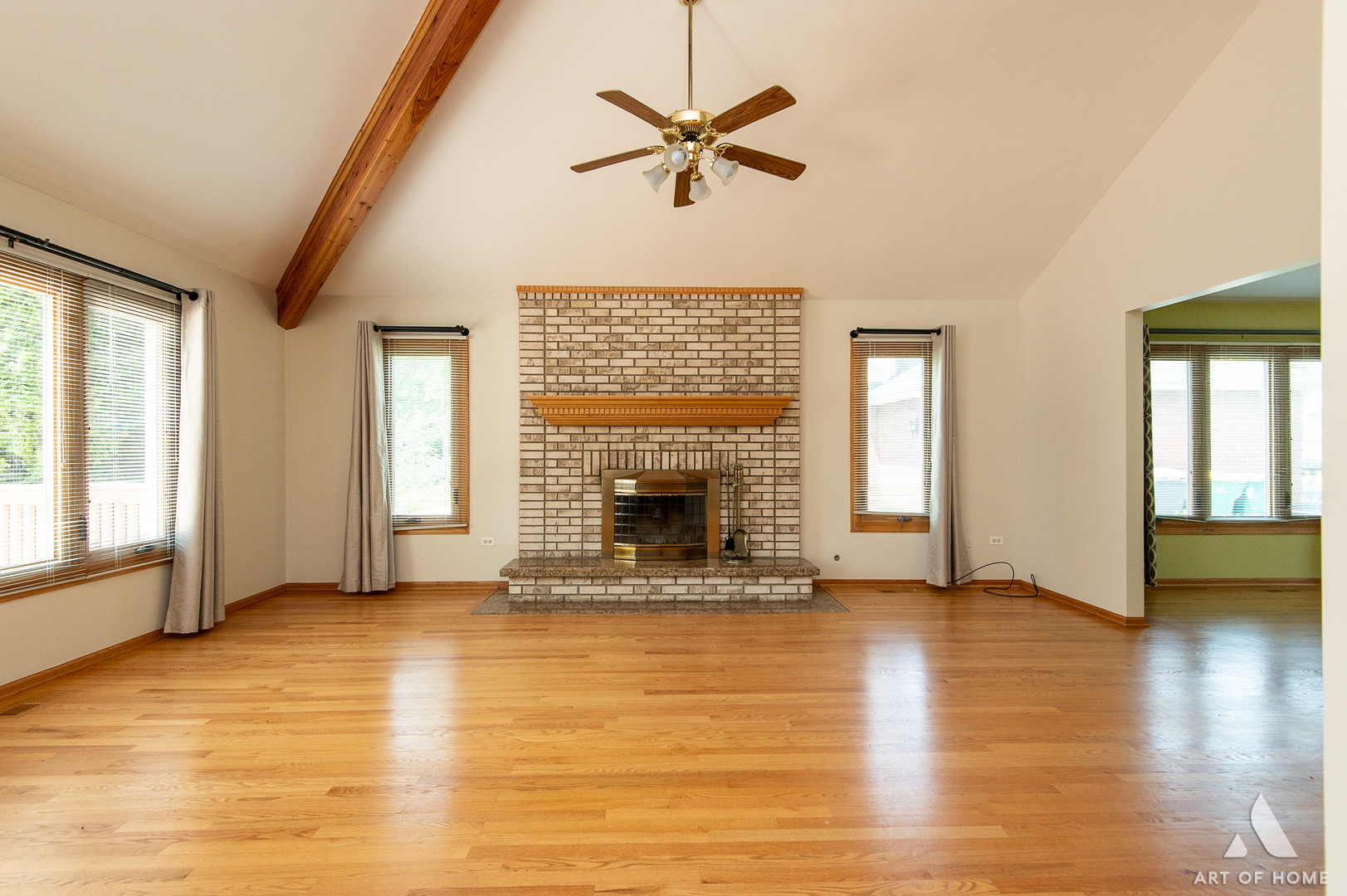 1196 Covington Drive Lemont, IL 60439 - Photo 14 of 52 an empty room with windows a fireplace a ceiling fan and wooden floor