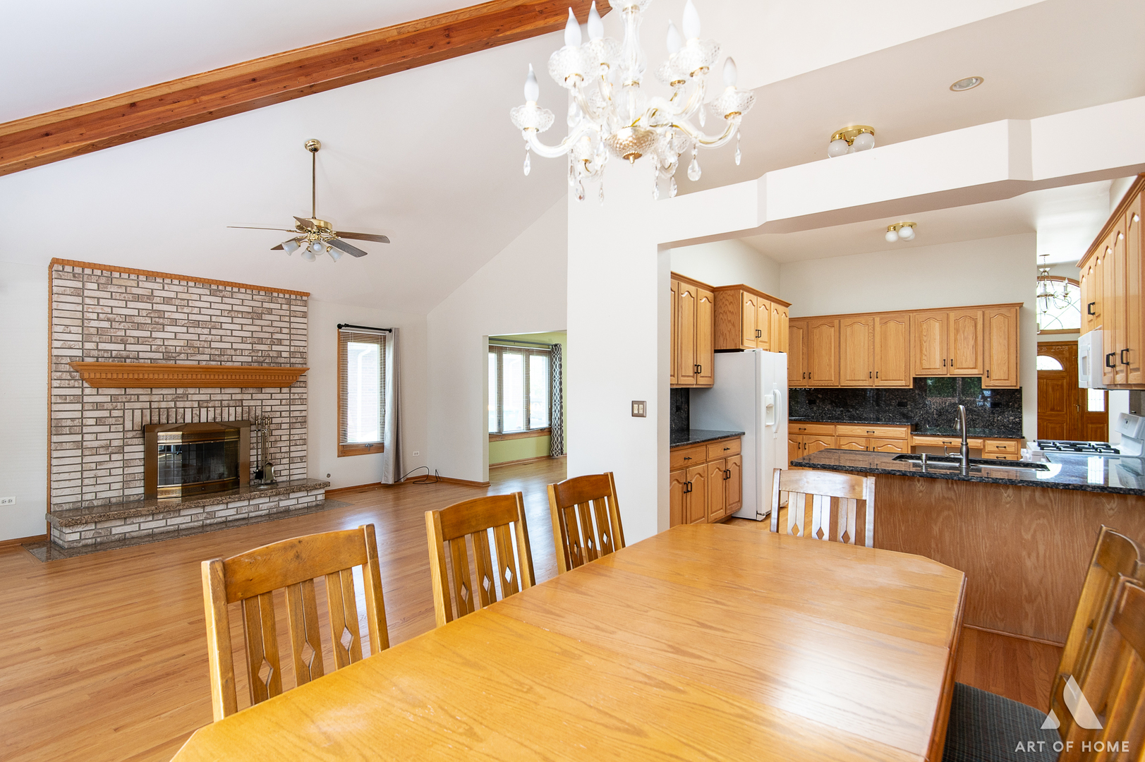 1196 Covington Drive Lemont, IL 60439 - Photo 10 of 52 a large white kitchen with granite countertop a stove top oven a sink a dining table and chairs with wooden floor