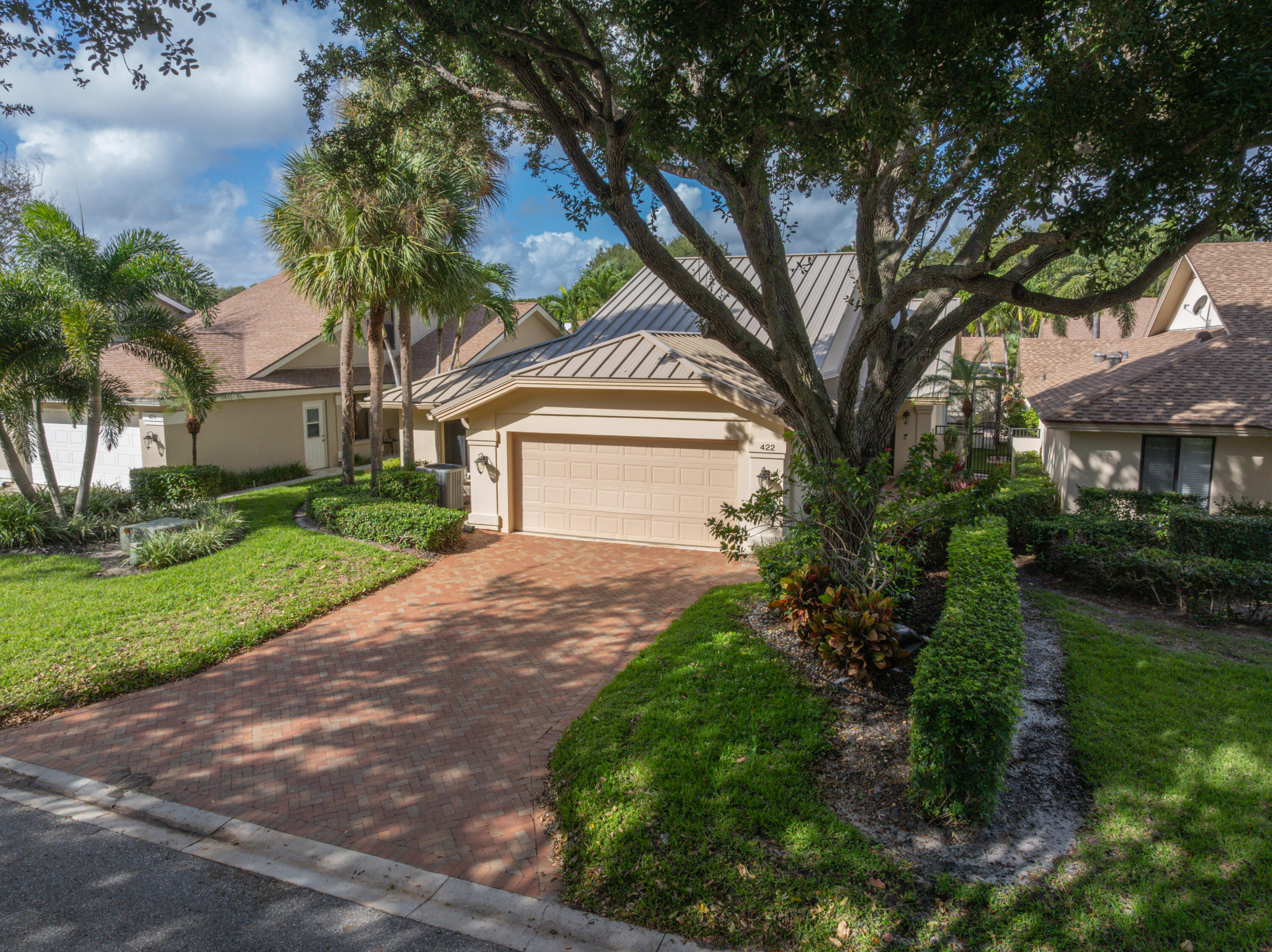 422 River Edge Road Jupiter, FL 33477 - Photo 2 of 39 a front view of a house with a garden and trees