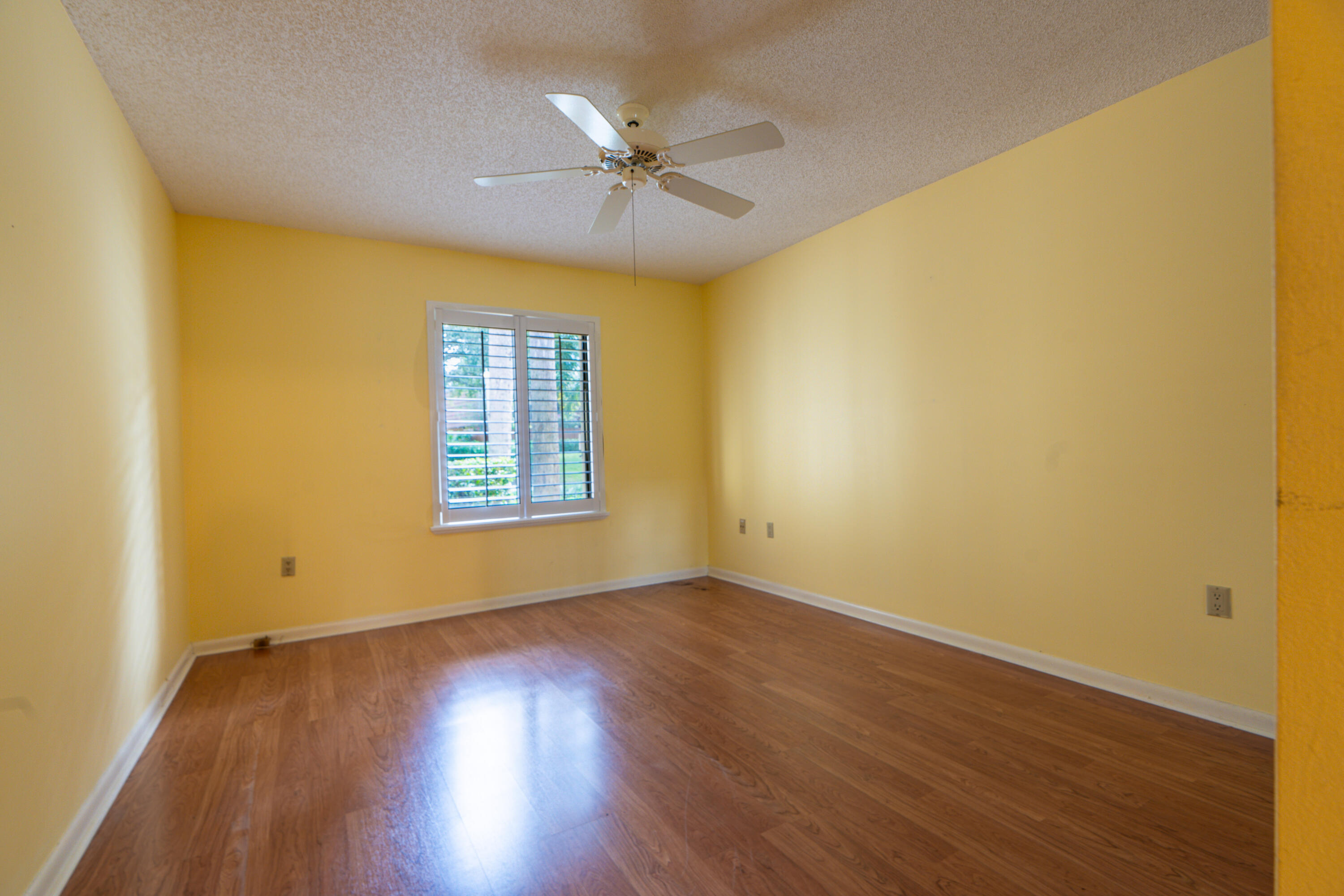 422 River Edge Road Jupiter, FL 33477 - Photo 37 of 39 a view of a big room with wooden floor a ceiling fan and windows