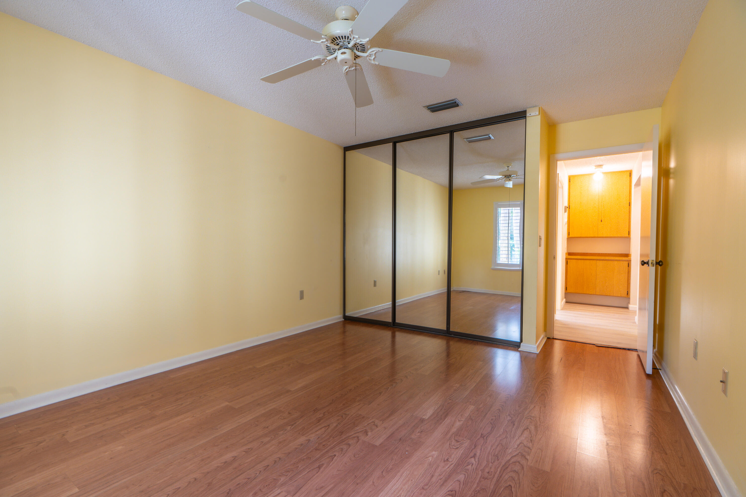 422 River Edge Road Jupiter, FL 33477 - Photo 38 of 39 an empty room with wooden floor fan and windows