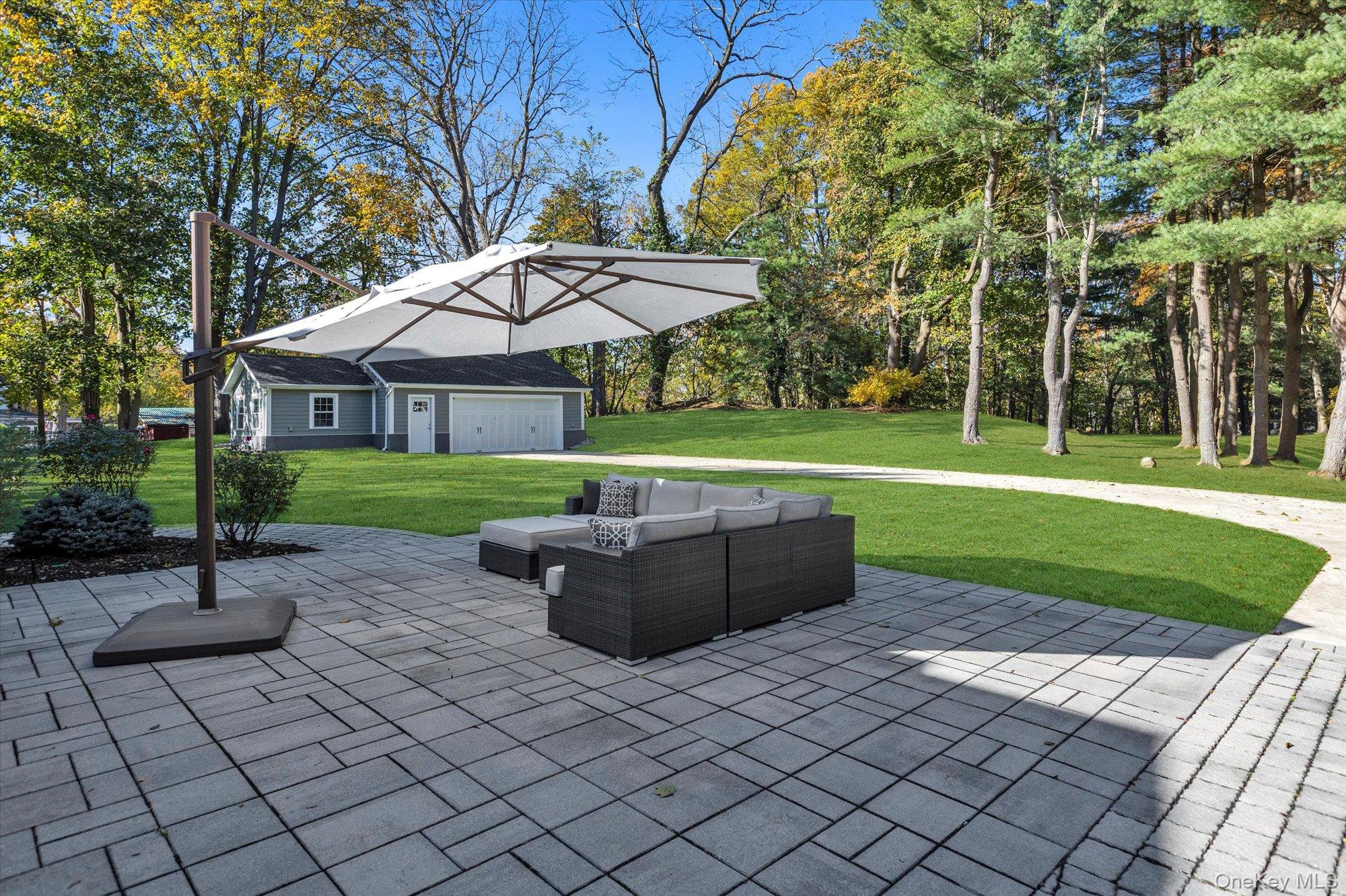 22 Fort Salonga Road Centerport, NY 11721 - Photo 38 of 42 a view of a backyard with table and chairs under an umbrella